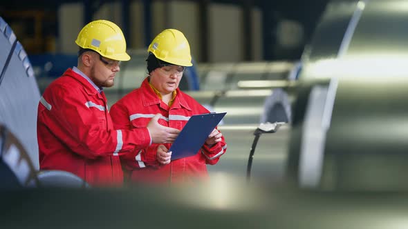 Two Workers in Production Plant As Team Discussing Industrial Scene in Background alt