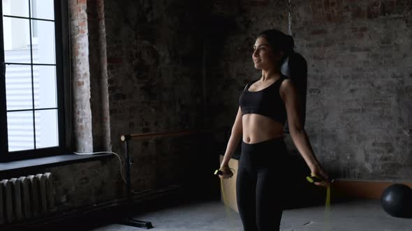 Slow Motion Shot of a Indian Woman in Her Forties Wearing Sports Clothing Jumping Rope alt