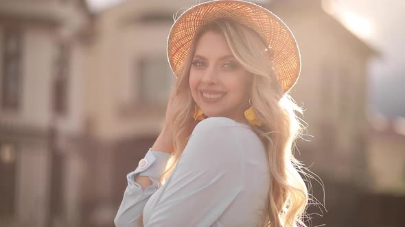 Beautiful Girl in a Summer Hat Posing in Sunlight