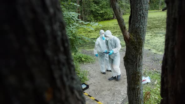 Criminalists Working with Proofs at Crime Scene Territory Closed with Signal Tape alt