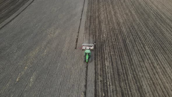 Top down view of farm being tilled for planting. Perfectly straight rows being plowed.