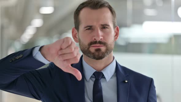 Portrait of Disappointed Businessman Doing Thumbs Down  alt