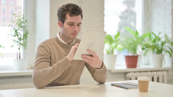 Man Using Tablet While Sitting in Office alt