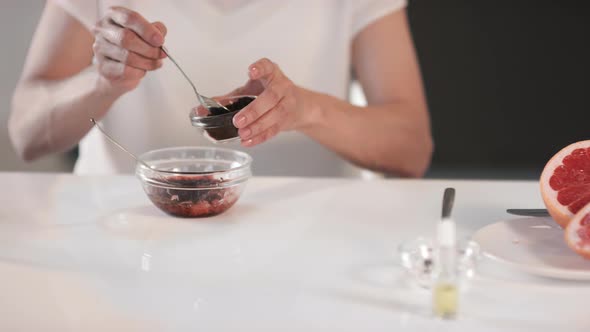Unrecognizable Woman Making Scrub From Coffee And Grapefruit alt