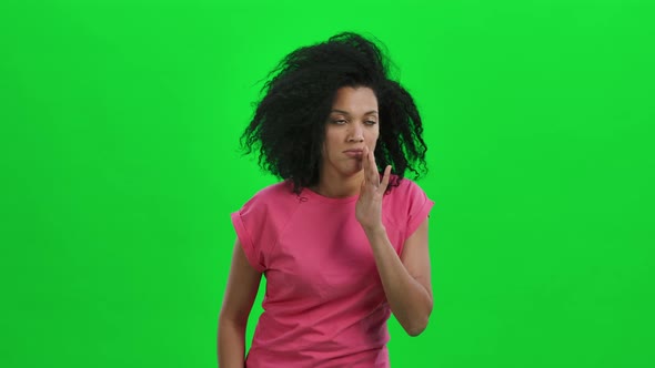 Portrait of Young Female African American Covering Her Mouth with Her Hand and Whispering the Secret alt