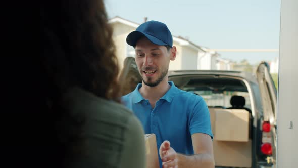 Delivery Guy Giving Cardboard Box to Female Client Using Smart Phone Talking Smiling alt