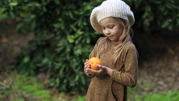 The Girl is Holding an Orange in Her Hands Closeup Slow Motion