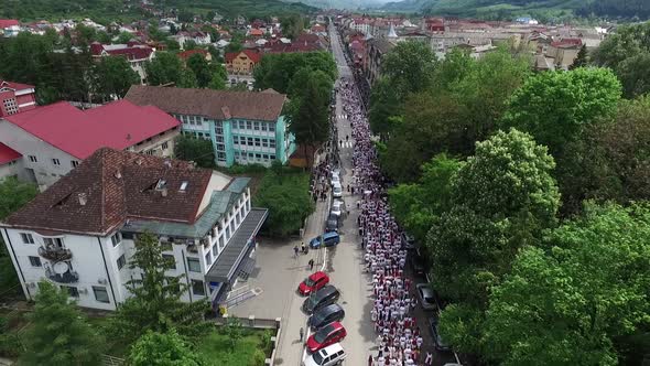 Aerial view of people in peasant clothes on a street alt