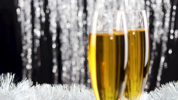Champagne in crystal glass with silver christmas tinsel on background