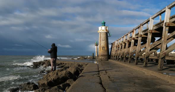A man fishing at entrance of the Capbreton's harbour, Landes department, Nouvelle Aquitaine, France alt