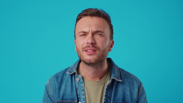 Young Handsome Man Shocked with Surprise Expression and Fear on Blue Background