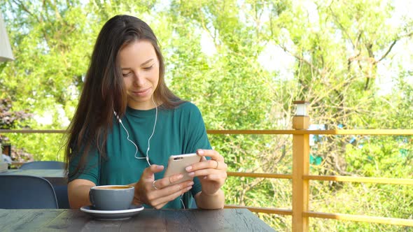 Young Woman Calling with Cell Telephone While Sitting Alone in Coffee Shop During Free Time
