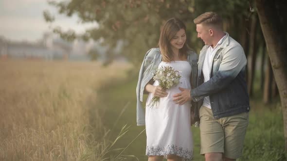 Beautiful Couple with Pregnant Woman in Forest