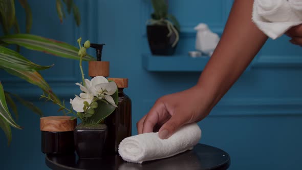 Closeup of Woman Hand Putting Small White Towels on Table Indoors alt