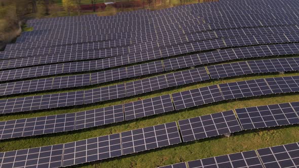 A large solar farm at sunset in Europe. Fast aerial orbit shot alt