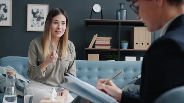 Stressed Woman Sharing Problems with Psychotherapist Talking and Gesturing Sitting on Couch in alt