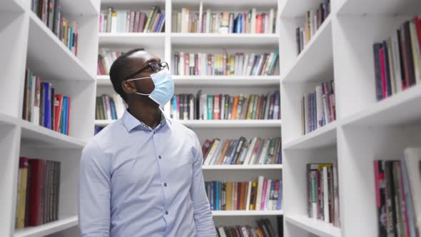 University Library: African American Man in a Mask During Quarantine Covid-19 Prepares for the Exam alt