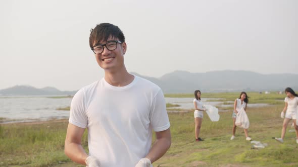 young Asia guy volunteers help to keep nature clean up.