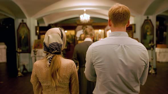 Blurry Parents Brought Their Baby for Christening in an Orthodox Church alt