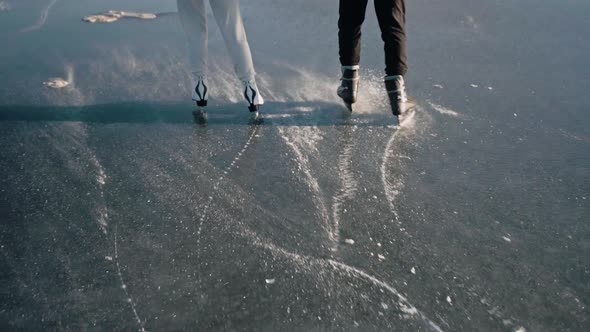 Shot of Couple's Legs Skating on a Clear Frozen Lake on a Sunny Winter Day