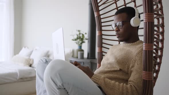 Young Student Listens to Educational Audio in Swinging Chair alt
