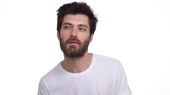 Young Relaxed Man Dancing Winking with Interest on White Background alt