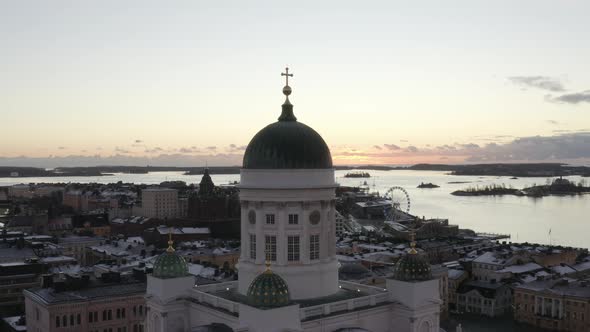Drone aerial view of Helsinki Cathedral with the sea and sunset on the background. alt