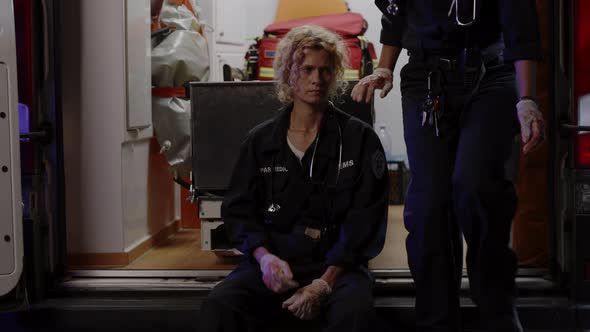 Disappointed Female Paramedic Sitting Near Ambulance Car alt