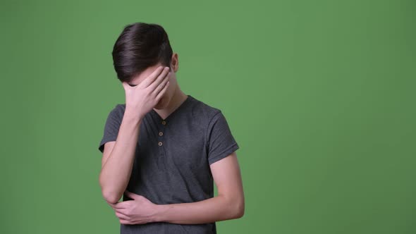 Young Handsome Iranian Teenage Boy Against Green Background alt
