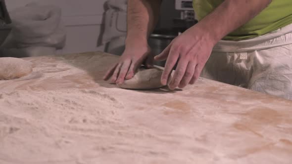 Slow Motion of Hands of Baker Chef Applying Flour on Dough