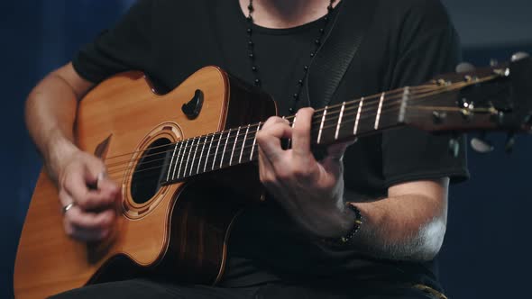 The Singer Plays an Acoustic Guitar at a Concert alt