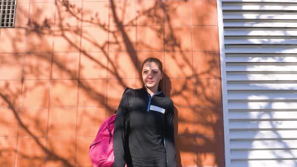Slow motion shot of woman with leg prosthesis leaning on a wall alt