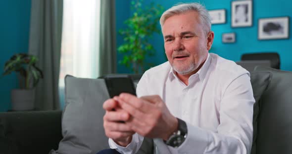 Gambling Bearded Elderly Senior 60s Years Old Using Play Mobile Cell Phone Hold Gadget Smartphone alt