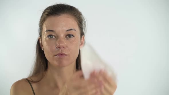 The Girl Removes the Mask From Her Face with a Sponge alt