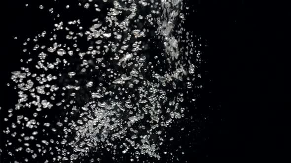 Slow Motion Stream of Water Drops Down in Aquarium on a Black Background alt
