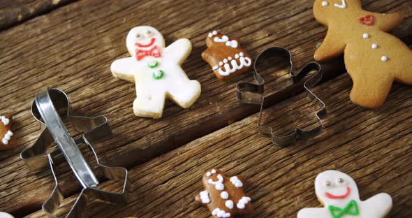 Cookie cutter and gingerbread cookies on wooden plank 4k alt