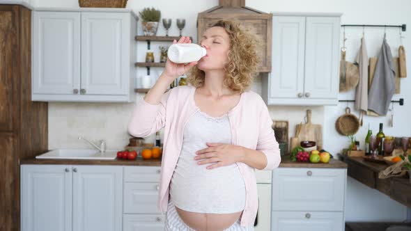 Young Pregnant Woman Taking Medicine Against Heartburn On Her Kitchen. Symptomatic Relief. alt