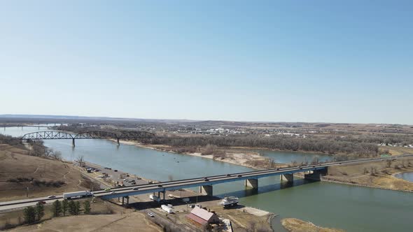 Landscape view of bridges over river. Dry dock seen in the lower corner. Blue sky.