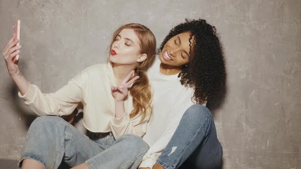 Two young beautiful smiling international hipster female in trendy summer jeans clothes alt