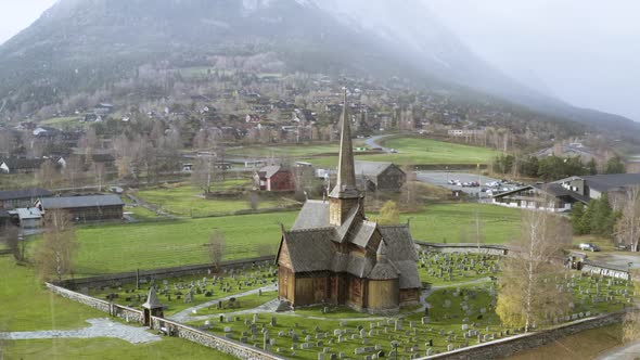 Lom Stave Church And Graveyard In Lom, Norway During Snowstorm Weather. Aerial Orbit alt