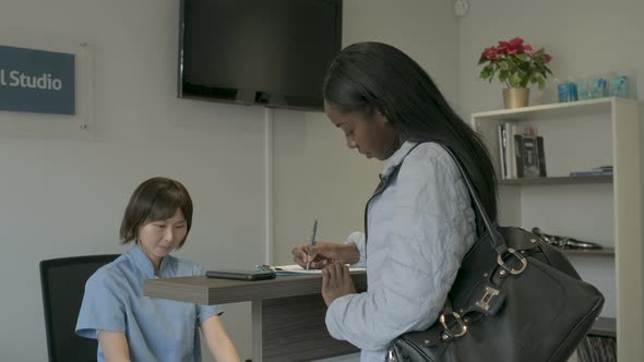 Patient filling out questionnaire at front desk alt