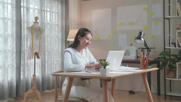Asian Woman Bag Designer With Layout Bond Using Laptop At The Office alt