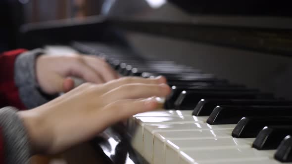Hands of Kid on Piano Keyboard