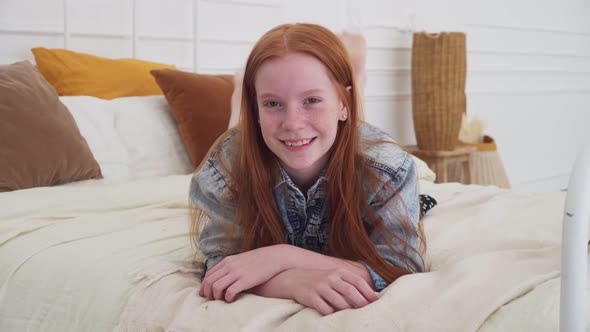 Pretty Teenage Girl with Freckles Smiling at Bedroom