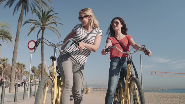 Young Adult Tourist cycling on beach in summer and taking selfie