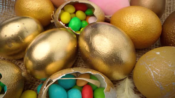 Golden Decorative Easter Eggs Filled with Colorful Candies on Wooden Table Close Up