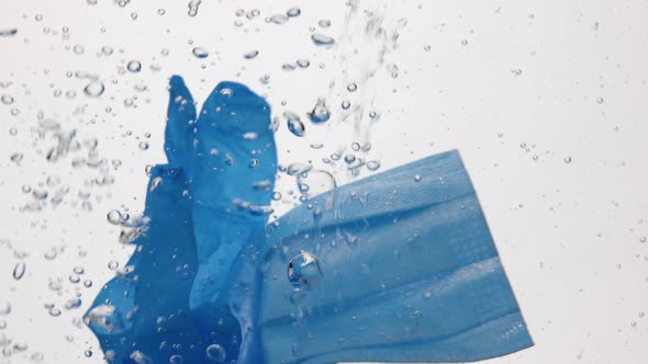 Masks and gloves in water over white