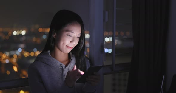 Woman use of cellphone at home in the evening alt