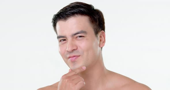 Young handsome confident smiling Hispanic man face in white isolated studio background