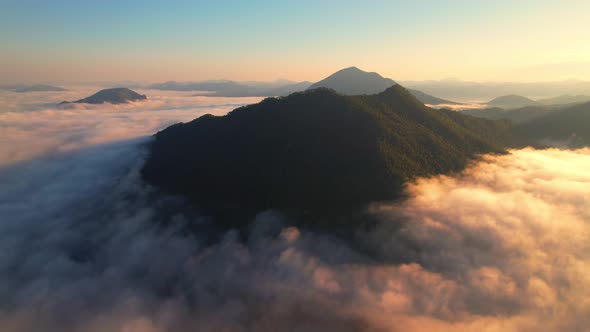 A sea of clouds above the valley and the mountains in the background alt